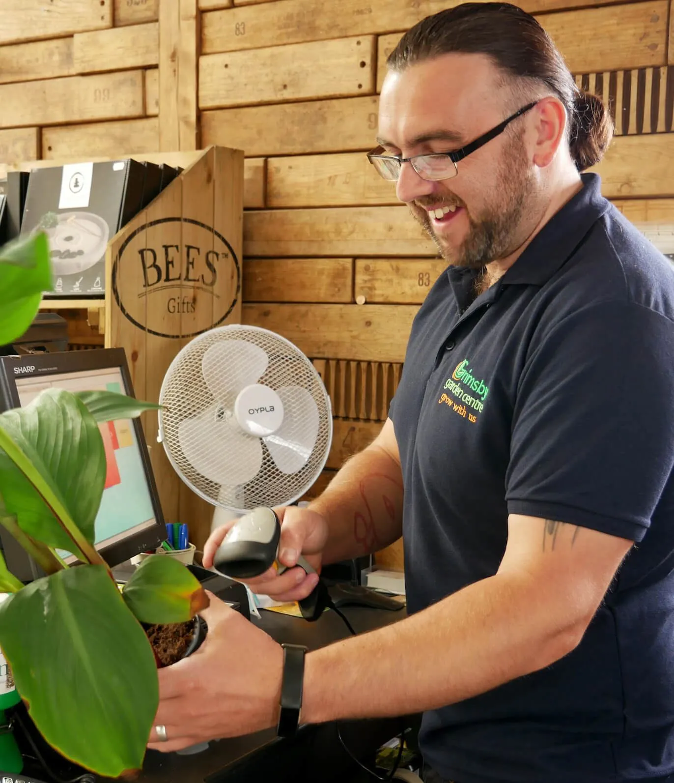 Craig working as a cashier scanning plants at Grimsby Garden Centre