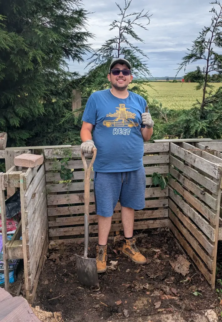 Louis standing on compost heap on allotment